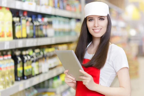 Улыбающийся работник супермаркета держит планшет — стоковое фото