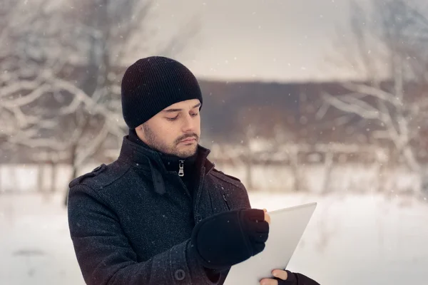 Hombre con la tableta fuera en la decoración de invierno —  Fotos de Stock