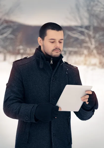 Homme avec tablette à l'extérieur en décor d'hiver — Photo