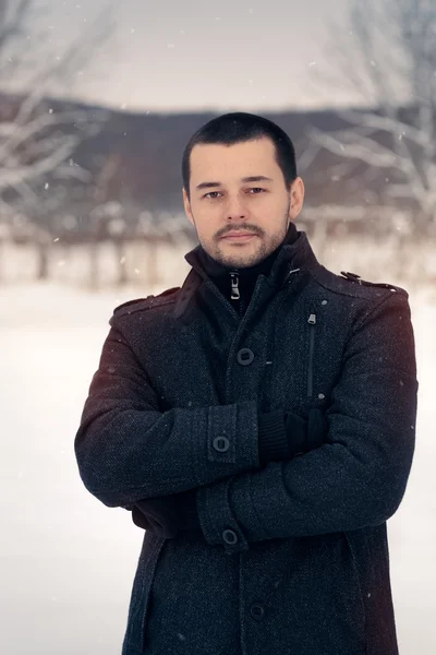 Hombre sonriente afuera en la decoración de invierno de nieve —  Fotos de Stock