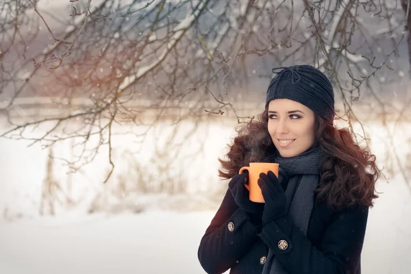 Mulher de inverno segurando uma caneca de bebida quente — Fotografia de Stock