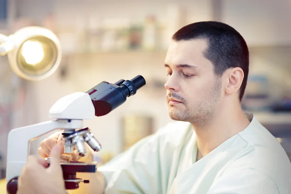 Jovem cientista masculino com microscópio — Fotografia de Stock