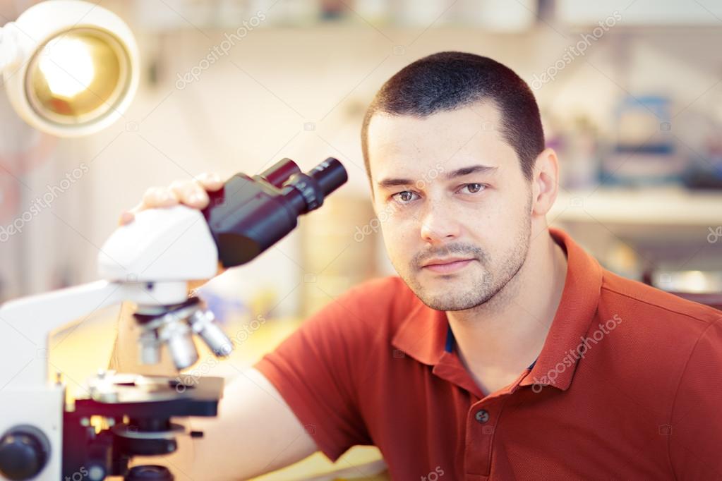 Young Male Researcher with Microscope