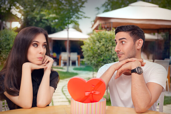 Удивлённая девушка получает от своего бойфренда подарок в форме сердца
