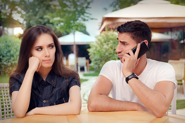Boos meisje luistert naar haar vriendje praten aan de telefoon — Stockfoto