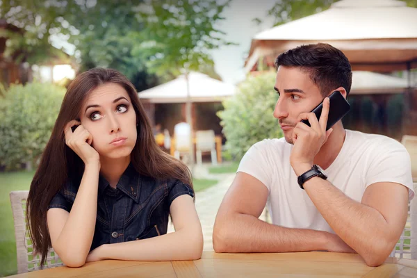 Meisje gevoel vervelen terwijl haar vriendje is op de telefoon — Stockfoto