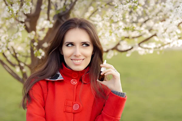 Usmívající se žena s respirační sprej na jaře kvetoucí dekor — Stock fotografie