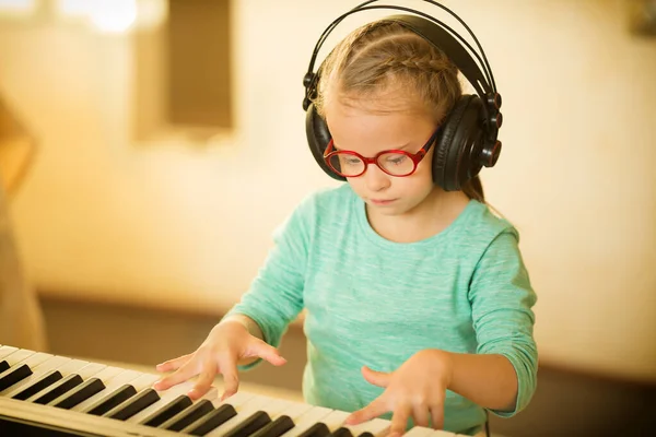 A girl with Down syndrome is learning to play the piano