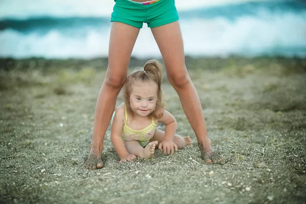 Kleines Mädchen Mit Syndrom Kriecht Zwischen Den Beinen Schwestern — Stockfoto