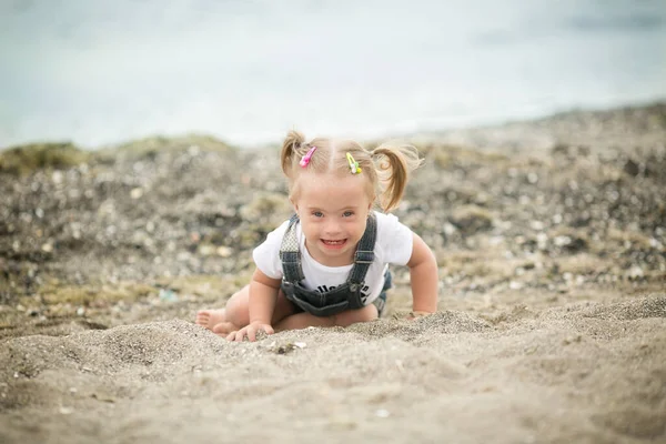 Dívka Downovým Syndromem Legrační Plazení Pláži — Stock fotografie