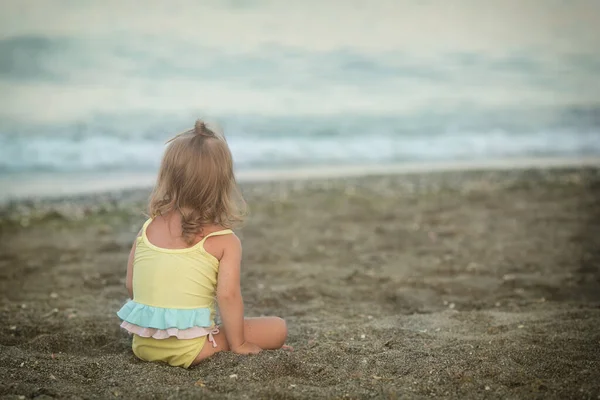 坐在沙滩上的患有唐氏综合症的女孩 — 图库照片