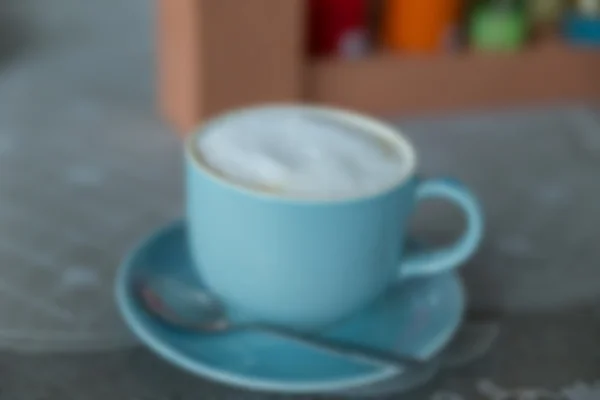 Imagen desenfocada de café con leche caliente en taza verde — Foto de Stock