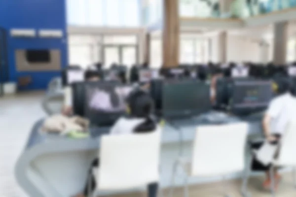 Elev bruger computer til at få adgang til internettet for uddannelse (sløret - Stock-foto