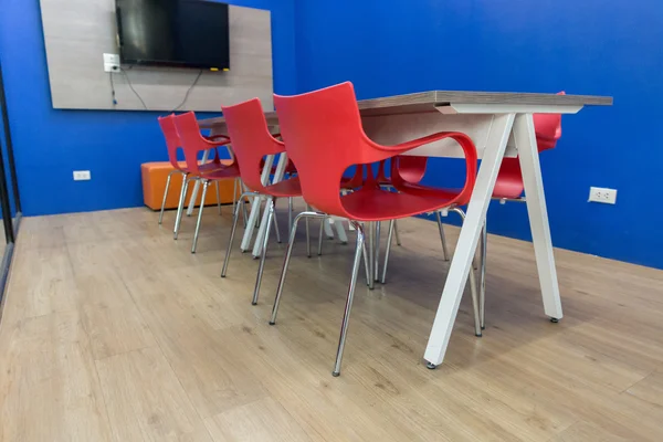Червоний стілець і дерев'яний стіл в кімнаті для переговорів — стокове фото