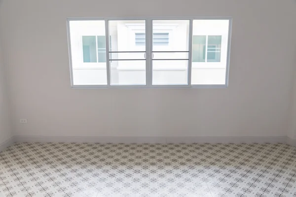 room with sliding window and beige tile floor