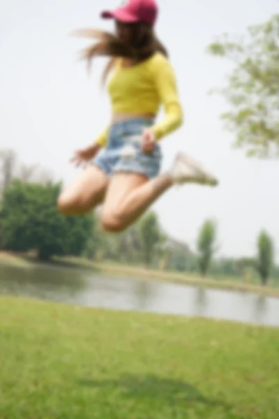 girl jumping in the park, blur and defocus