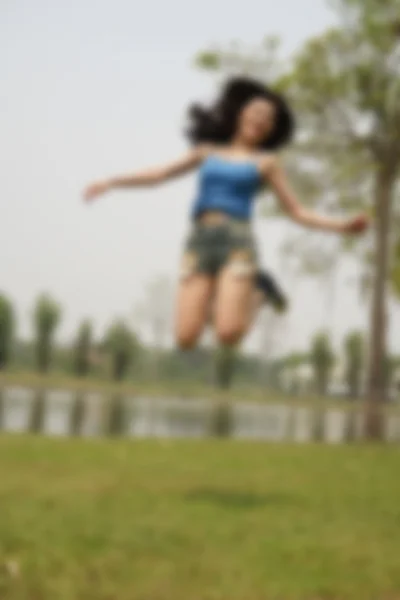 Fille sautant dans le parc, flou et défocus — Photo