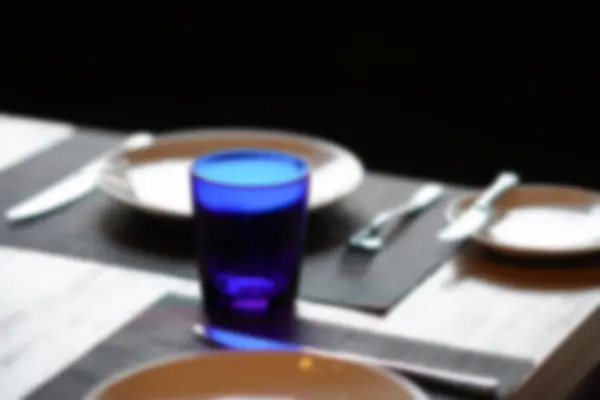 Schüssel, Löffel, Gabel und blaues Glas auf Holztisch, Unschärfe und Entschärfung — Stockfoto