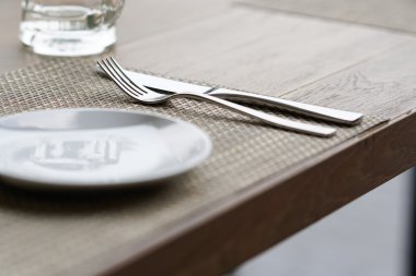 boş bardak kupa, çatal bıçak takımı ve beyaz tabak 