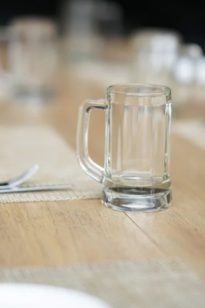 Leerer Glasbecher, Besteck und weiße Schale — Stockfoto