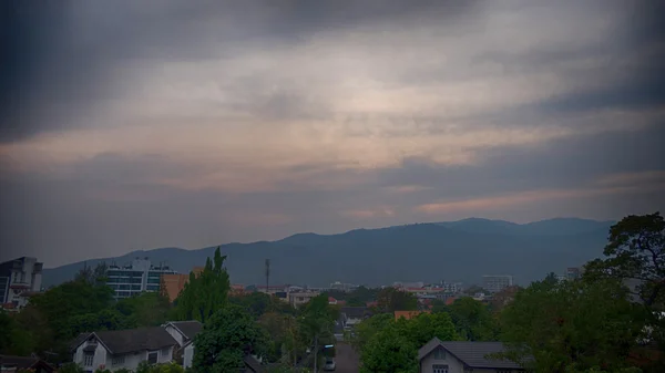 Вид на горы и город в облаках в сумерках — стоковое фото