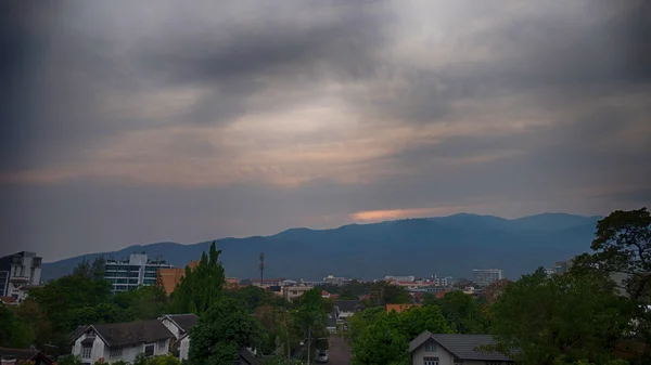 Vista de la montaña y la ciudad en el paisaje nublado al atardecer del crepúsculo —  Fotos de Stock