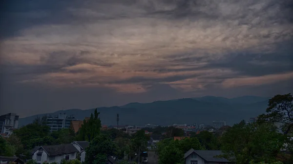 Вид на горы и город в облаках в сумерках — стоковое фото