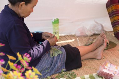 Yaşlı kadın muz yaprak katlama