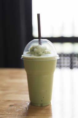 ahşap masa üzerinde yeşil çay smoothie