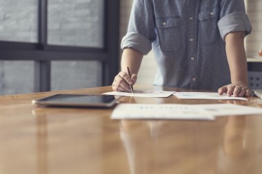 kadın eli çalışma belgesi ve tablet, seçici odak ile bir