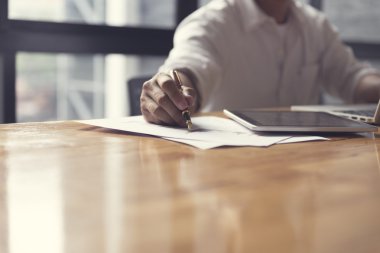 Adamın elini dizüstü bilgisayar ve işletme belgesi ile çalışma