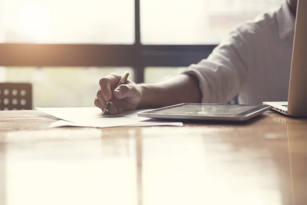 Mano del hombre que trabaja con el ordenador portátil y el documento de negocios — Foto de Stock