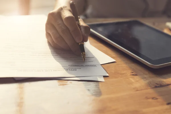 Formulario de solicitud de firma de mano de hombre con tableta en mesa de madera — Foto de Stock