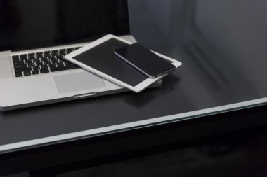 dizüstü bilgisayar, dijital tablet ve siyah masa üstünde hareket eden telefon