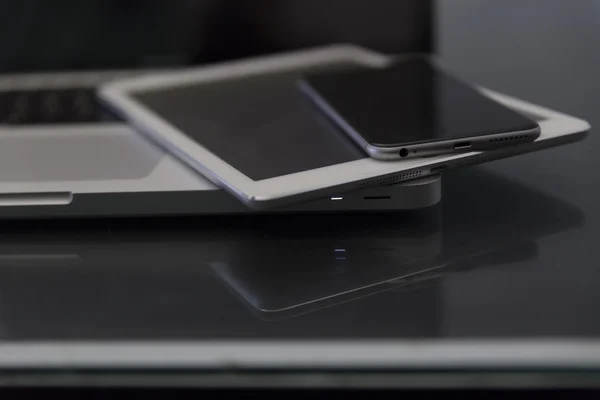 Ноутбук, цифровой планшет и мобильный телефон на черном столе — стоковое фото