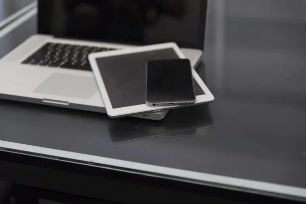Computer portatile, tablet digitale e telefono cellulare su tavolo nero — Foto Stock