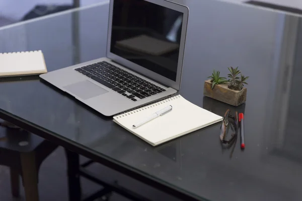 Stift, Notizbuch und Laptop auf schwarzem Tisch — Stockfoto