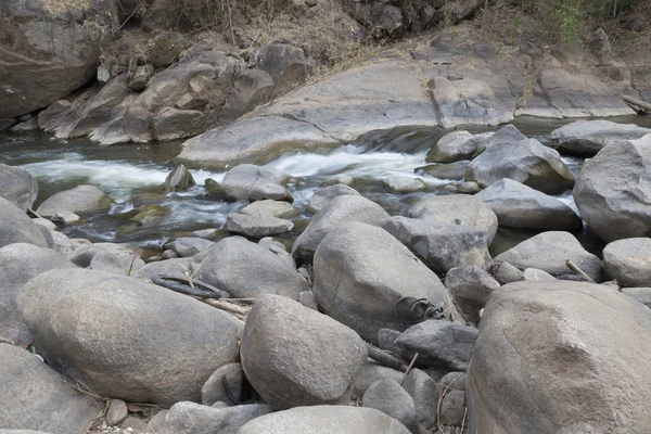 Vattenströmmen genom stenen i creek — Stockfoto