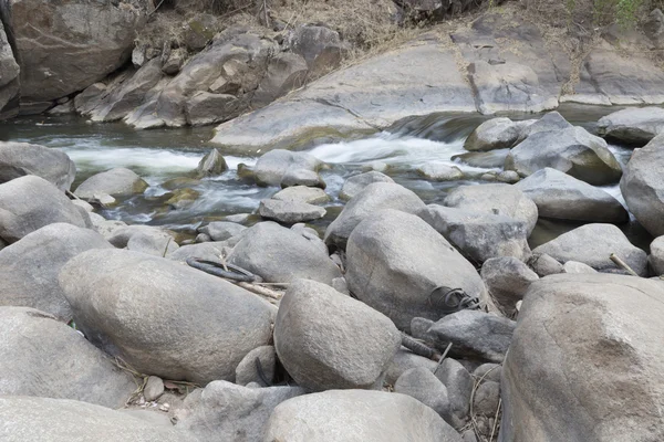 Поток воды через камень в ручье — стоковое фото