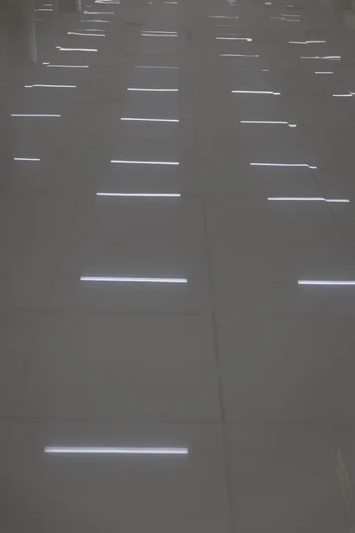 Reflection of fluorescent bulb on tile floor — Stock Photo, Image