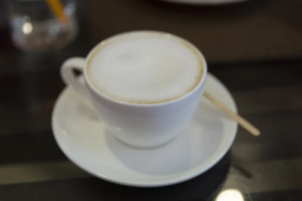 Tasse de café latte chaud avec lumière bokeh, fond flou — Photo