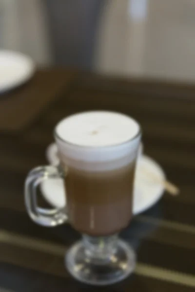 Taza de café capuchino caliente, fondo borroso — Foto de Stock