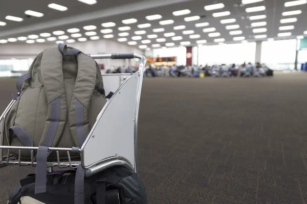 Mochila no carrinho no edifício terminal do aeroporto — Fotografia de Stock