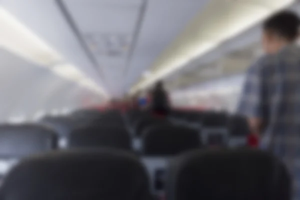 Människor som vandrar i mittgången i flygplan, oskärpa bakgrund — Stockfoto