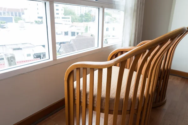 wooden chair beside window