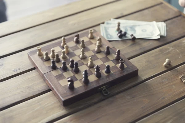 棋子、 棋盘游戏和木制的桌子，复古色调上钞票 — 图库照片