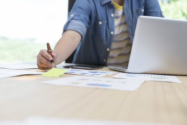 woman with laptop computer, document and pen on desk
