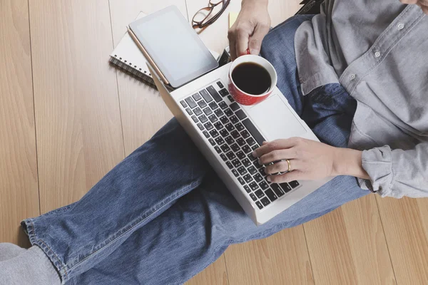 Man med bärbar dator, kaffekopp och tablet - ovanifrån — Stockfoto