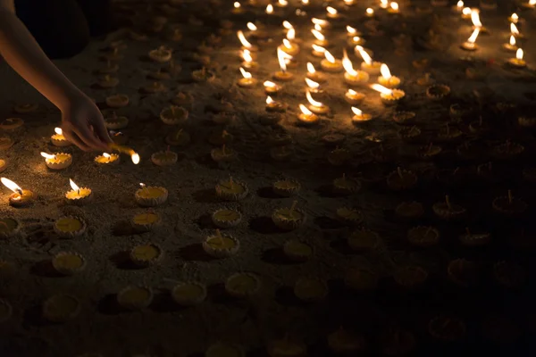 Folk tænder stearinlys for at vise respekt for Buddha levn - Stock-foto