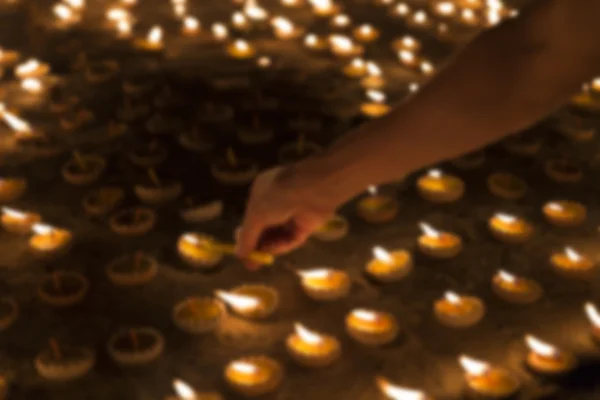 La gente enciende velas para pagar respeto a la reliquia de Buda - imagen borrosa — Foto de Stock